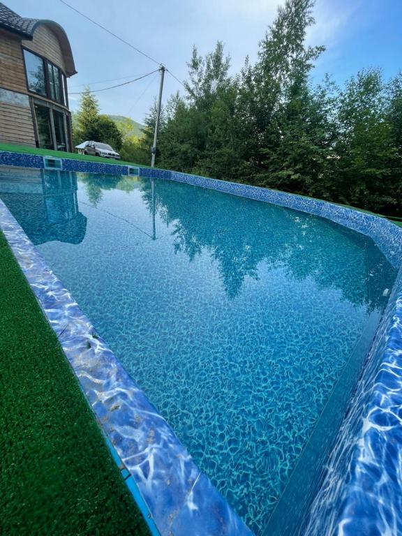 a swimming pool with blue water in front of a house at RIVIERA in Lekechi
