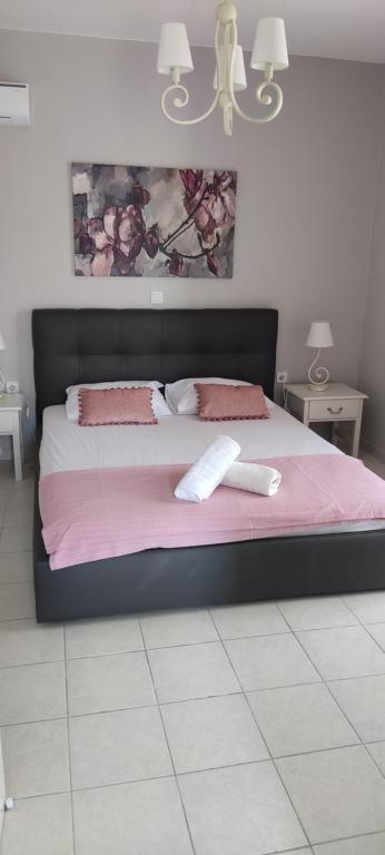 a bedroom with a large bed with pink sheets at SIMPLICITY in Marmari