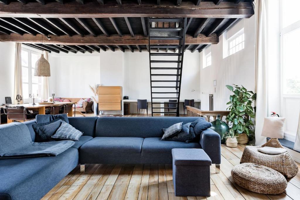a living room with a blue couch and a loft at PAKHUIS in Ghent