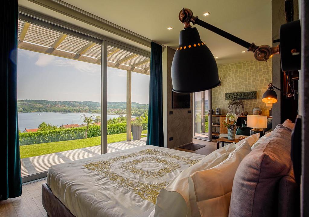 a bedroom with a bed and a large glass window at The Lake House in Viverone