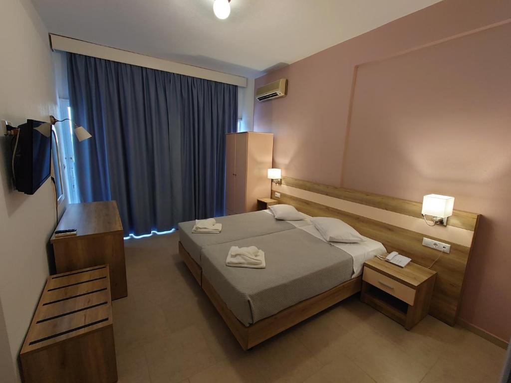 um quarto de hotel com uma cama e uma televisão em Ifigenia Hotel em Skiathos