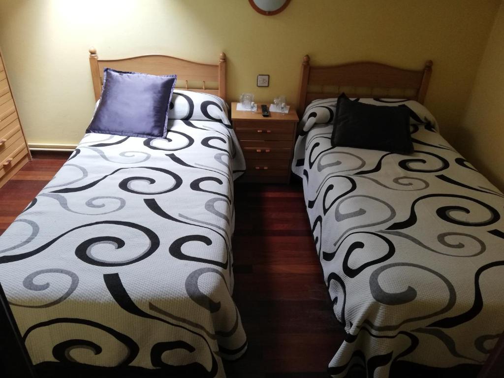 2 Betten nebeneinander in einem Zimmer in der Unterkunft Pensión Rosa in Cabezón de la Sal
