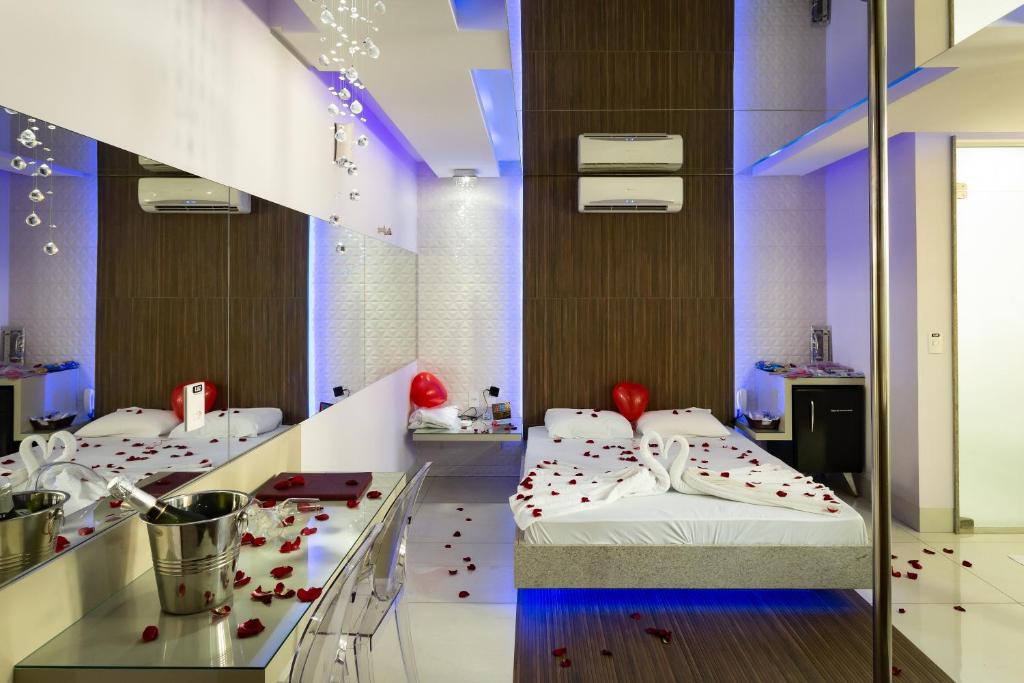 two beds in a room with red hearts on the floor at MIRAGEM MOTEL in Rio Verde