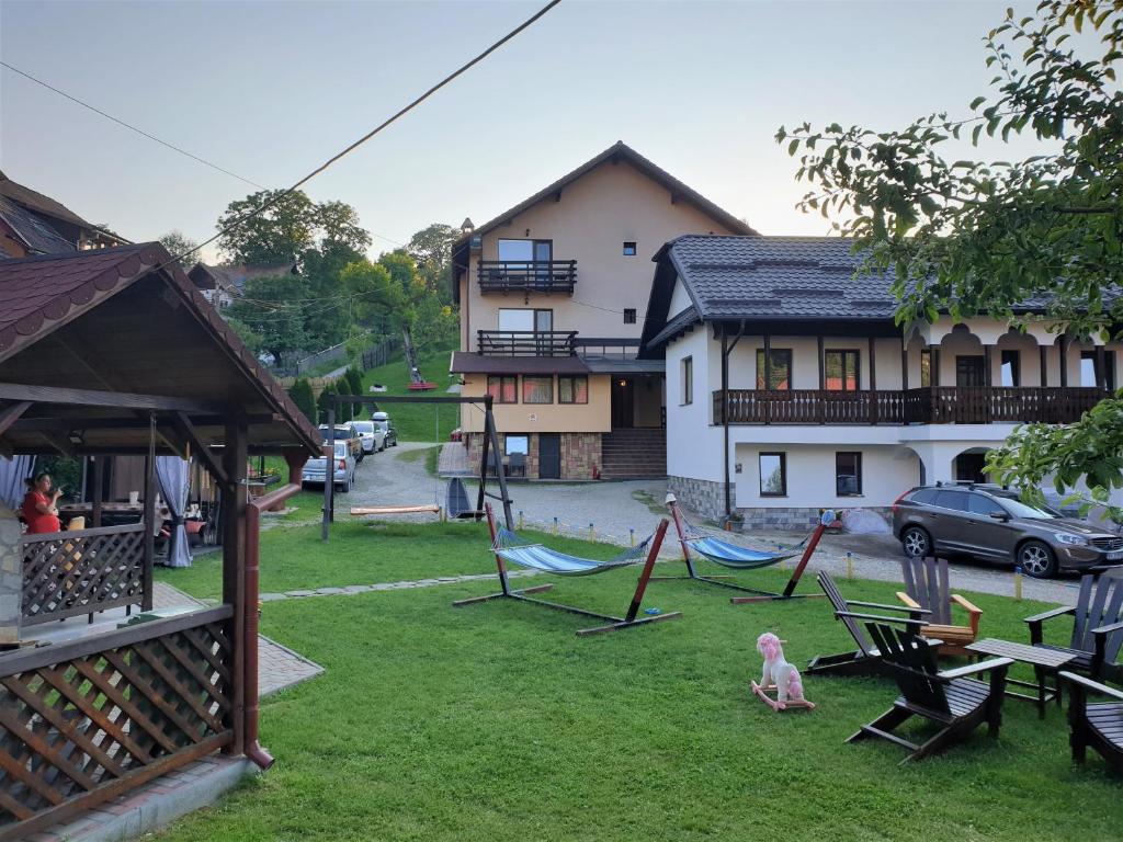 un patio con sillas y hamacas frente a una casa en Pensiunea Sarah Bran, en Bran