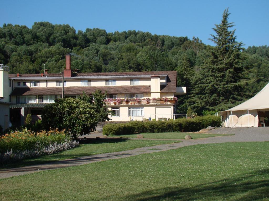 - un grand bâtiment blanc avec une tente en face dans l'établissement Villa Baviera, Hotel Baviera Chile, à La Máquina