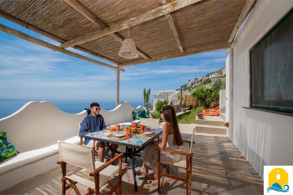 een man en een vrouw aan een tafel op een patio bij Casa Francisca in Praiano