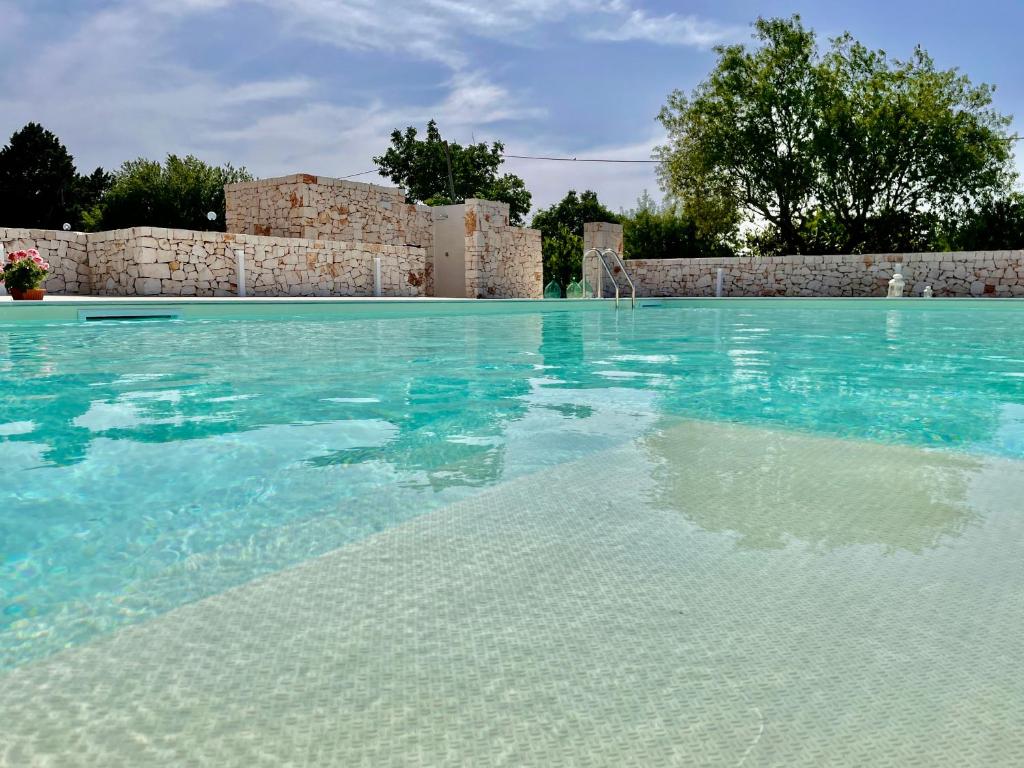 una piscina con acqua blu e un edificio di Loggia Dei Lezzi a Noci