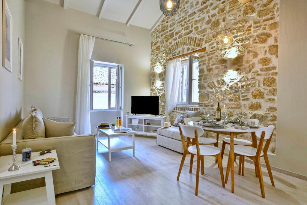 ein Wohnzimmer mit einem Tisch und einer Steinmauer in der Unterkunft NV LUXURY RESIDENCE in Korfu-Stadt