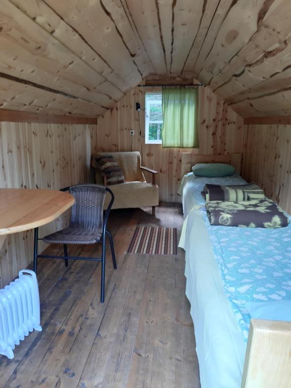 a room with two beds and a table at Kipi-Koovi Matkakeskuse väiksem majake in Kipi