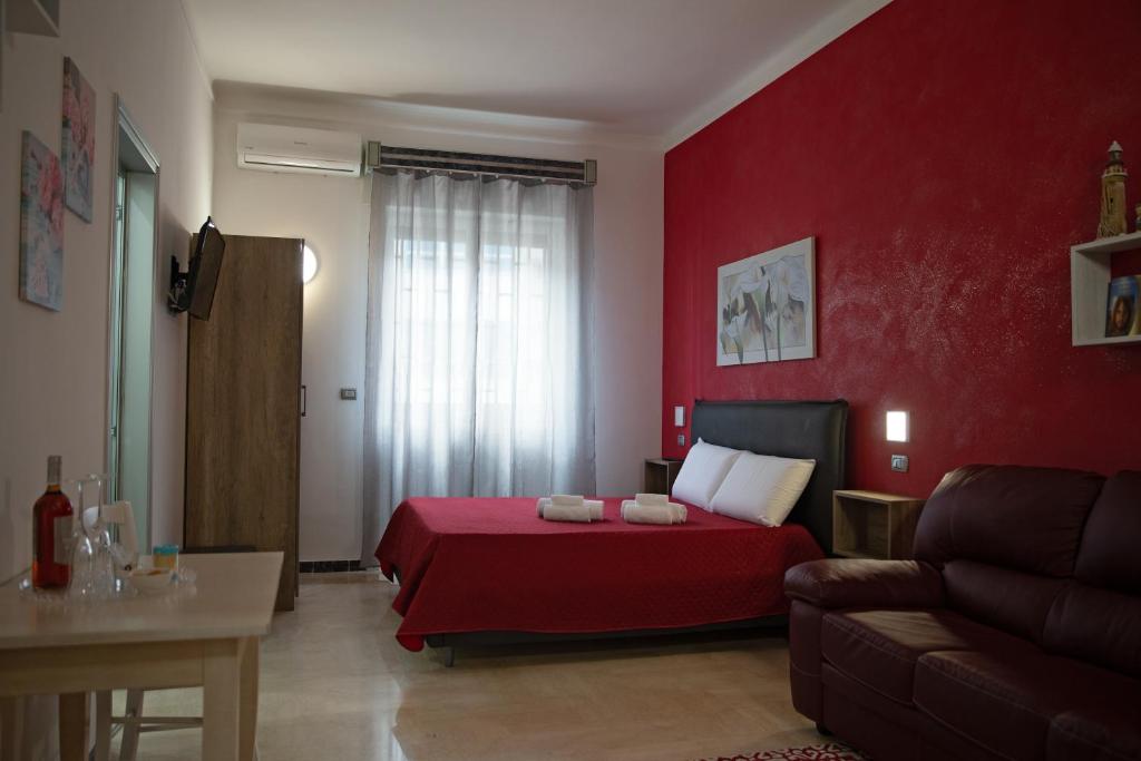 萊切的住宿－Li Cumpari salentini，红色卧室配有床和沙发