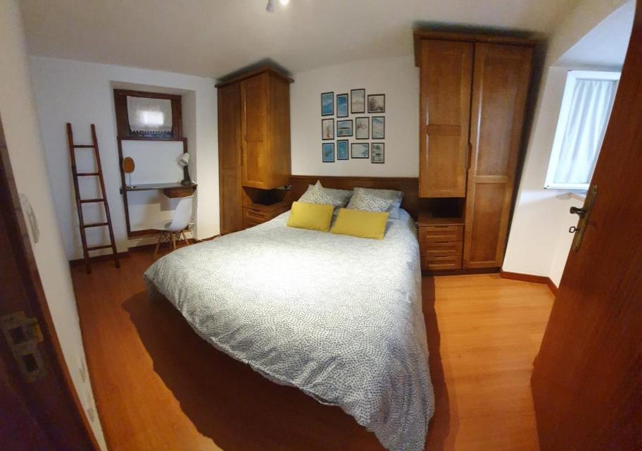 ein Schlafzimmer mit einem Bett mit zwei gelben Kissen in der Unterkunft Casinha dos Figueirais in Góis