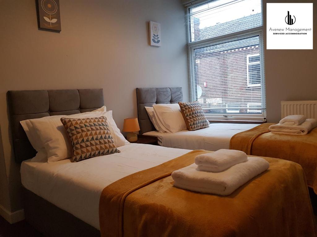 a room with two beds and a window at The Townhouse at Avenew Management Serviced Accommodation Stoke-on-Trent with Free Parking & WIFI in Hanley