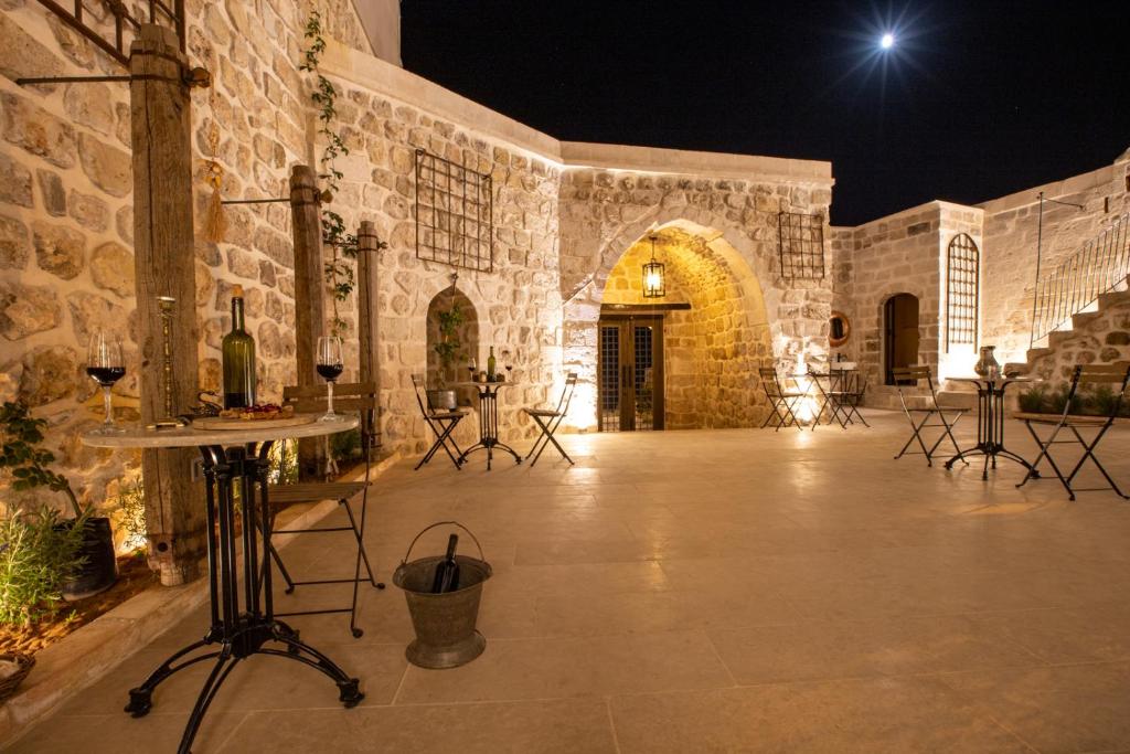 ein Steingebäude mit einer Terrasse in der Nacht in der Unterkunft Mirsoum Hotels in Mardin