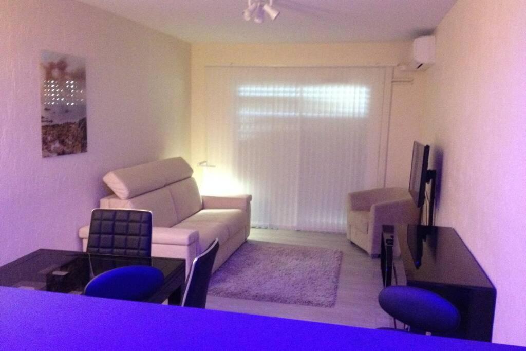 a living room with a white couch and blue chairs at Beau Studio à 50m de la plage in Nice