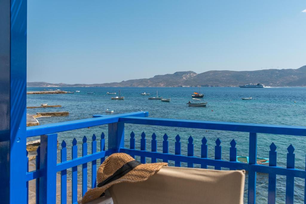 een stoel op een blauw hek met uitzicht op het water bij Traditional and Sailor's Sirma Klima in Klima