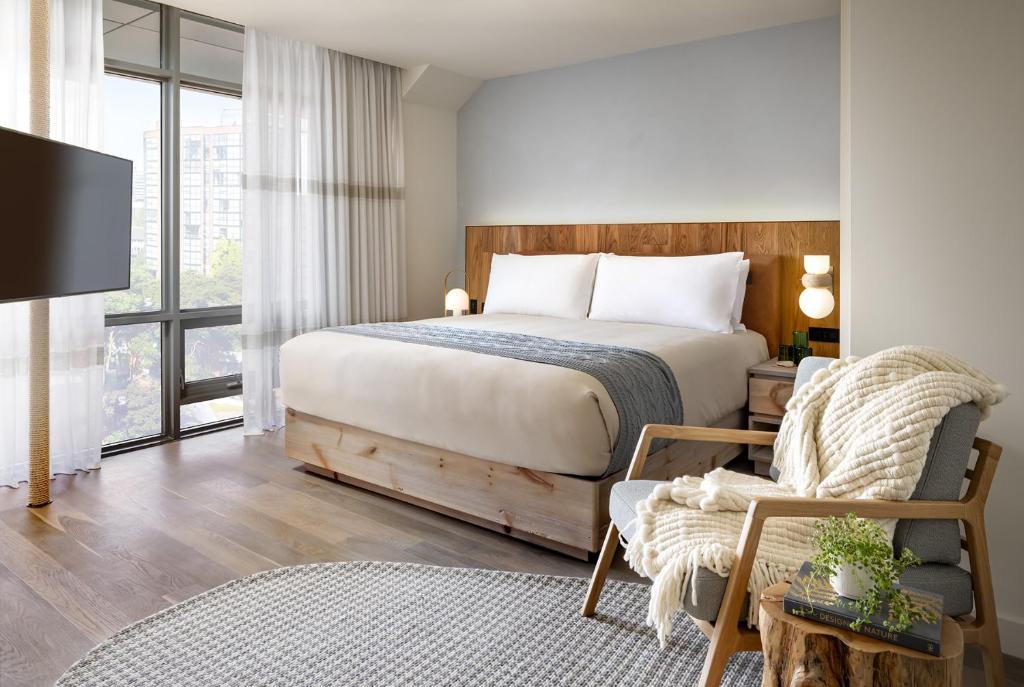 a bedroom with a bed and a chair and a tv at 1 Hotel Toronto in Toronto