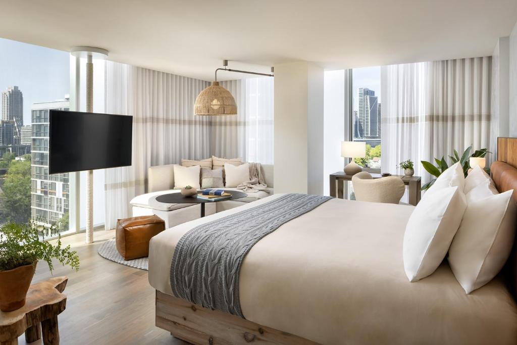 a bedroom with a large bed and a living room at 1 Hotel Toronto in Toronto