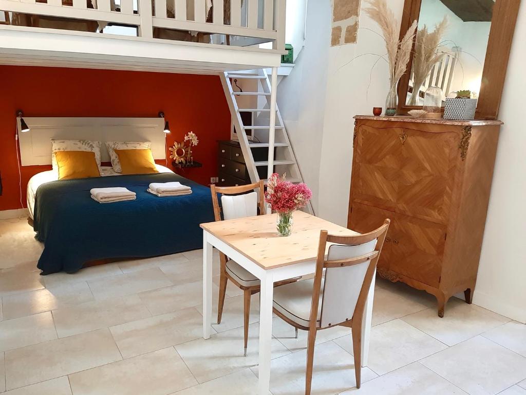a bedroom with a bed and a table and a bunk bed at En plein Coeur : charmant gite centre Amboise in Amboise