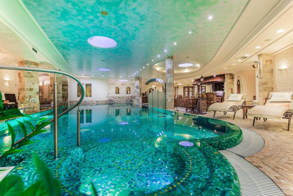 a swimming pool in a hotel with a blue ceiling at Carlsbad Plaza Medical Spa & Wellness hotel in Karlovy Vary