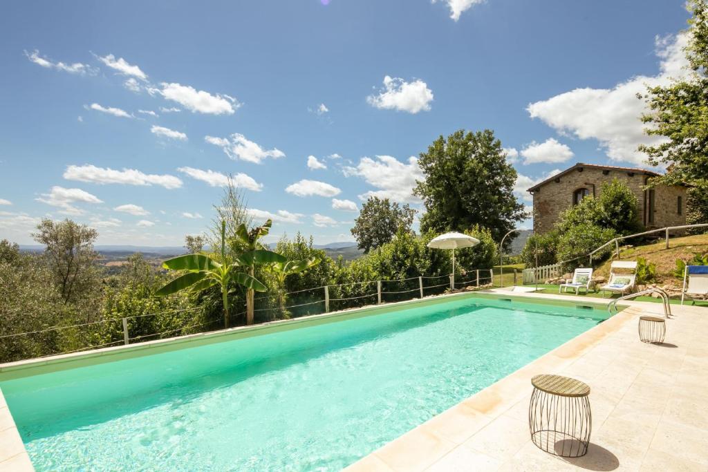 a swimming pool with a view of a house at Villa le Casine in San Cristoforo a Perticaia