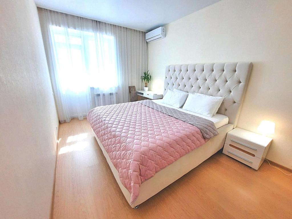 - une chambre avec un grand lit et une grande fenêtre dans l'établissement Alex Apartment Сеть апартаментов Бесконтактное заселение 24-7, à Poltava