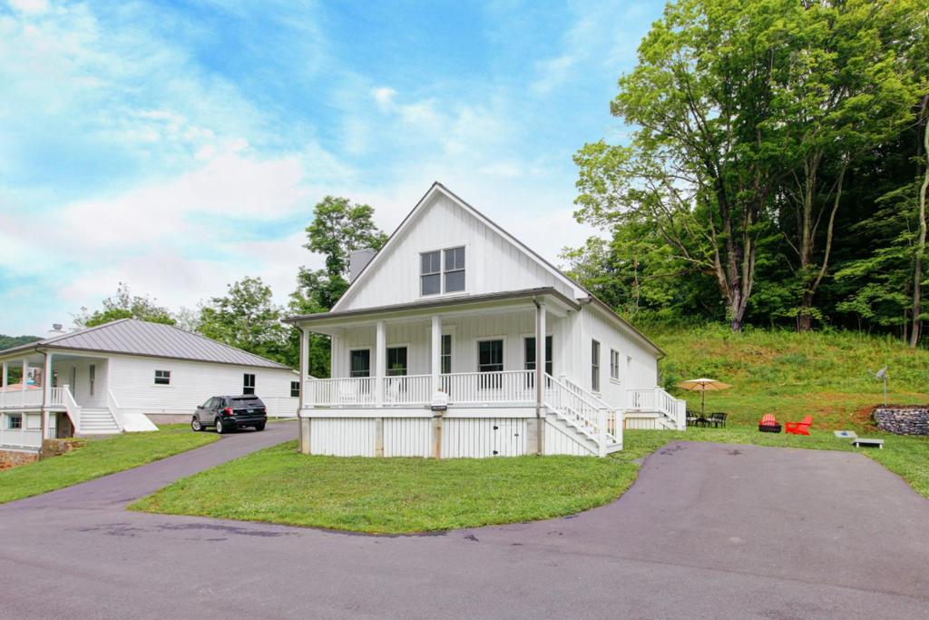 uma casa branca com um carro estacionado na garagem em Monroe Cottage em Hot Springs