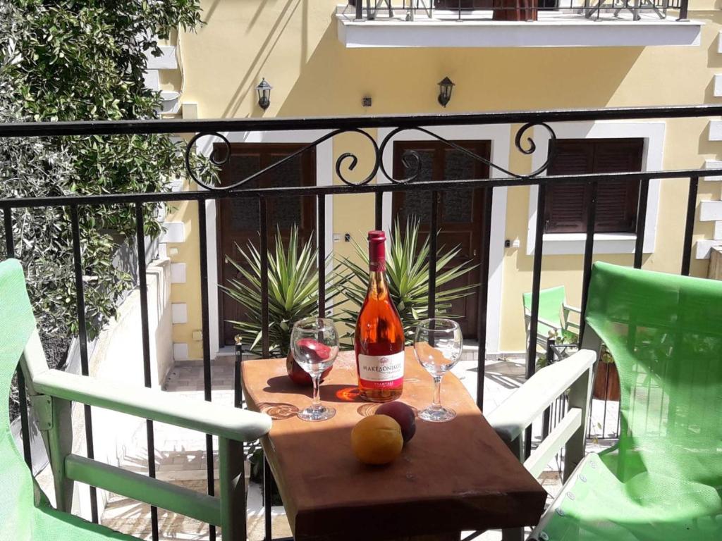 a bottle of wine sitting on a table with two glasses at Dourios Ippos Apartments in Frikes