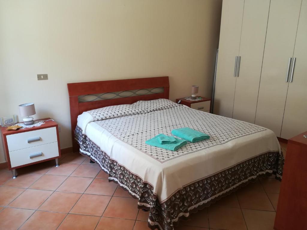 1 dormitorio con 1 cama y 2 toallas verdes en Casa Silipi, en Gallico