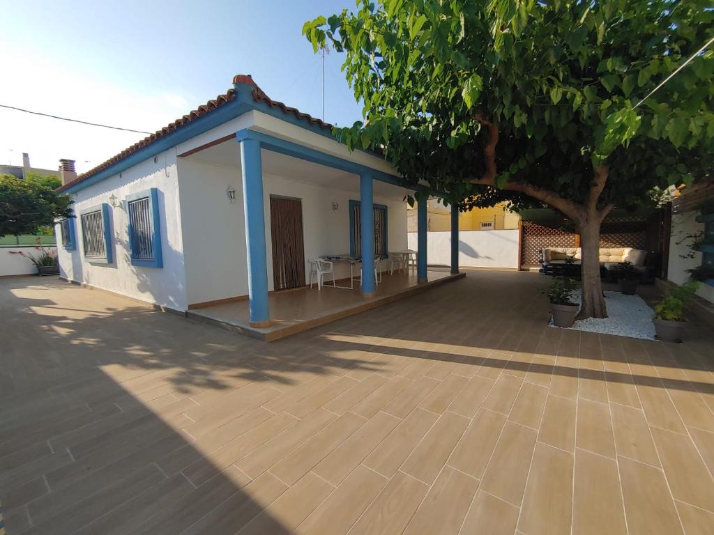una pequeña casa blanca con un árbol y un patio en Chalet playa, en Benicarló