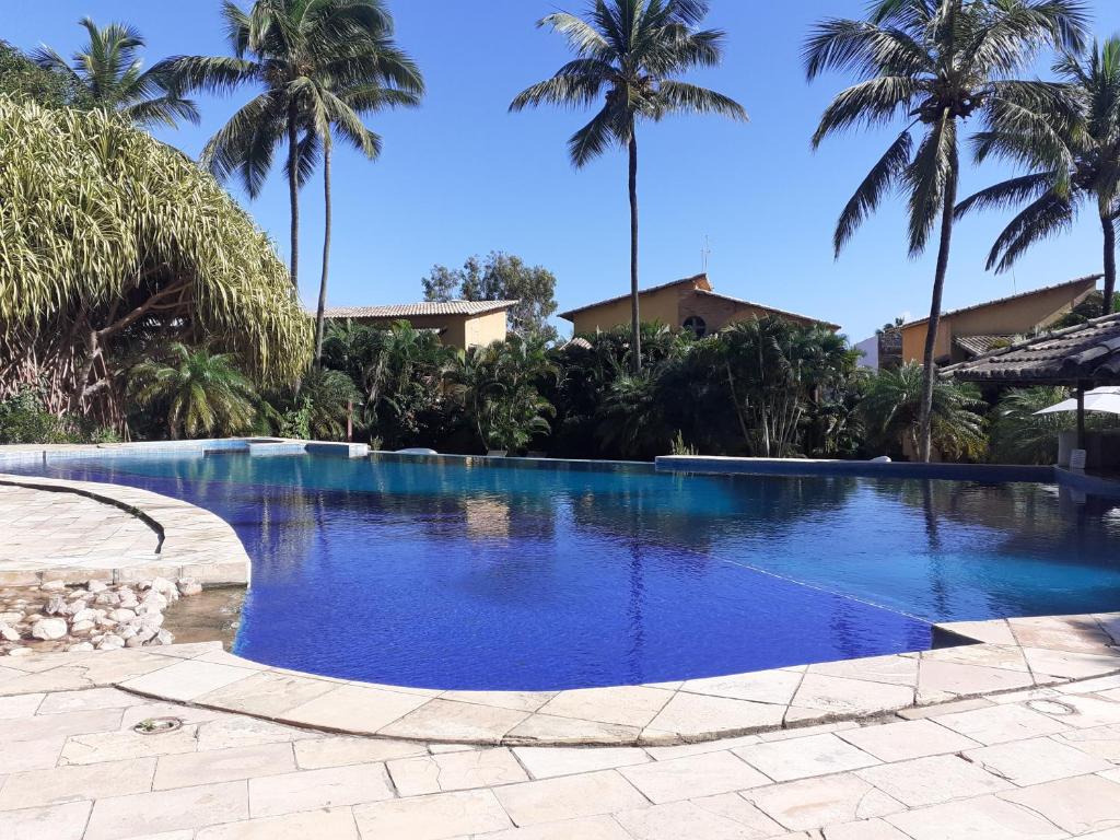 una gran piscina con palmeras en el fondo en Casa Girassois en Pipa