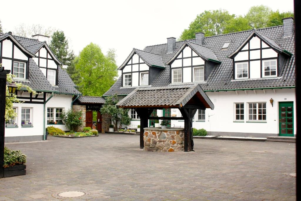 uma grande casa com um pavilhão num pátio em Altenbruecker Muehle em Overath