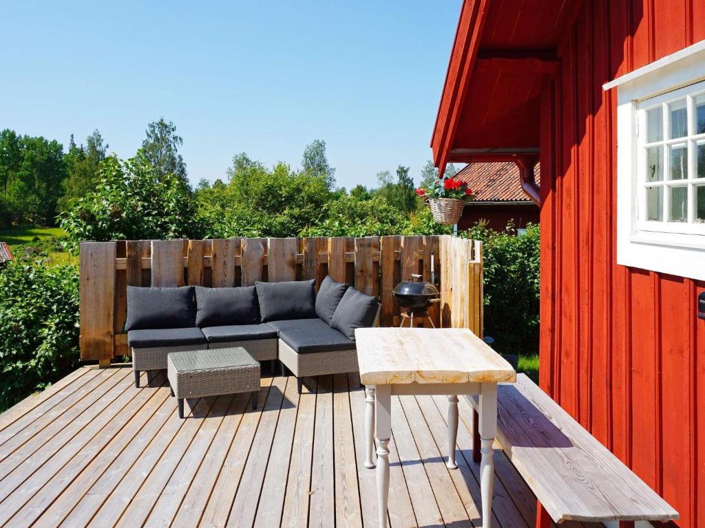 a patio with a blue couch on a wooden deck at 5 person holiday home in Mell sa in Mellösa