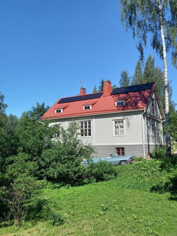 a large white house with a red roof at Villa Puistola Vinttimajoitus in Hämeenlinna