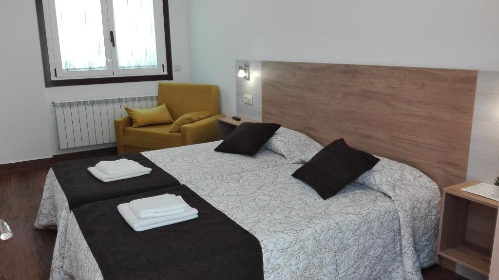 una habitación de hotel con una cama y una silla en Hostel Boente, en Boente