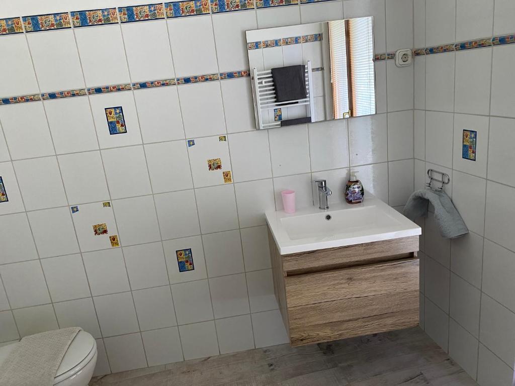 łazienka z umywalką i lustrem w obiekcie Gimi Vendégház w mieście Baja