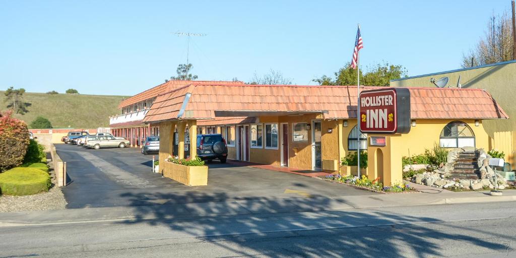 a small yellow building with a corner inn sign at Hollister Inn in Hollister
