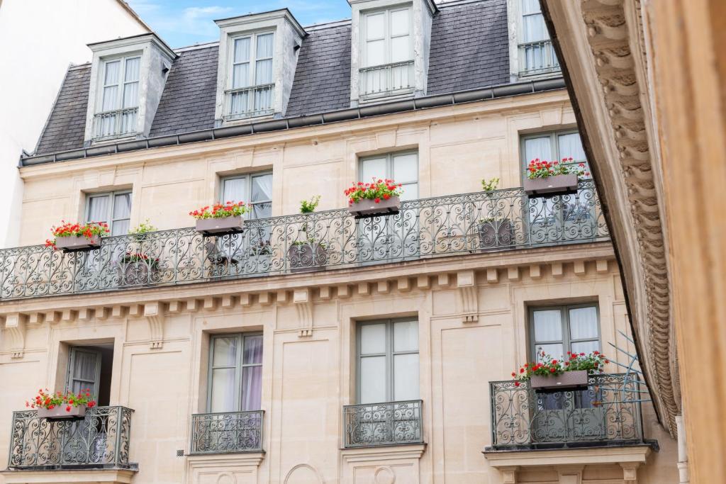 un edificio con macetas en los balcones de París en Hôtel Aston, en París