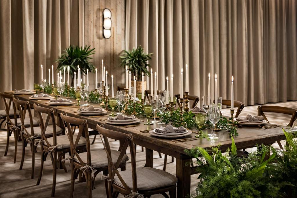 a long wooden table with chairs and candles on it at 1 Hotel Toronto in Toronto