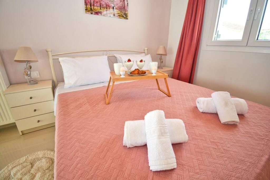 Drosáton的住宿－Casa Lydia Drosato Corfu，一间卧室配有一张带桌子和毛巾的床