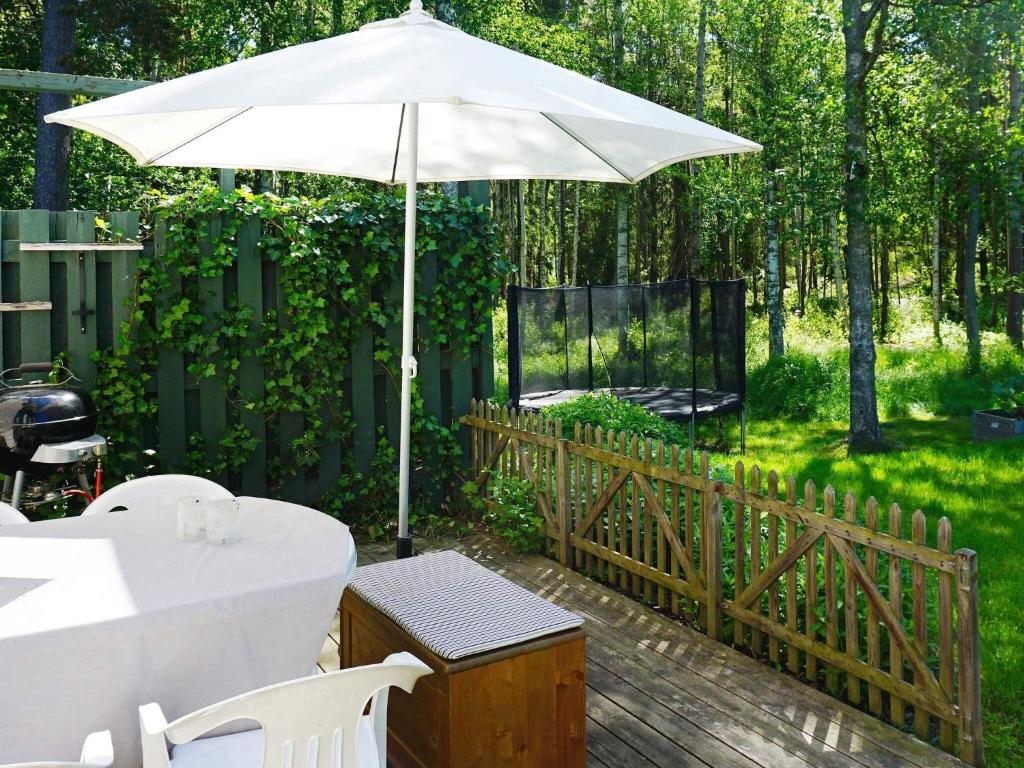 易克略的住宿－6 person holiday home in EKER，木制甲板上的一个白色遮阳伞