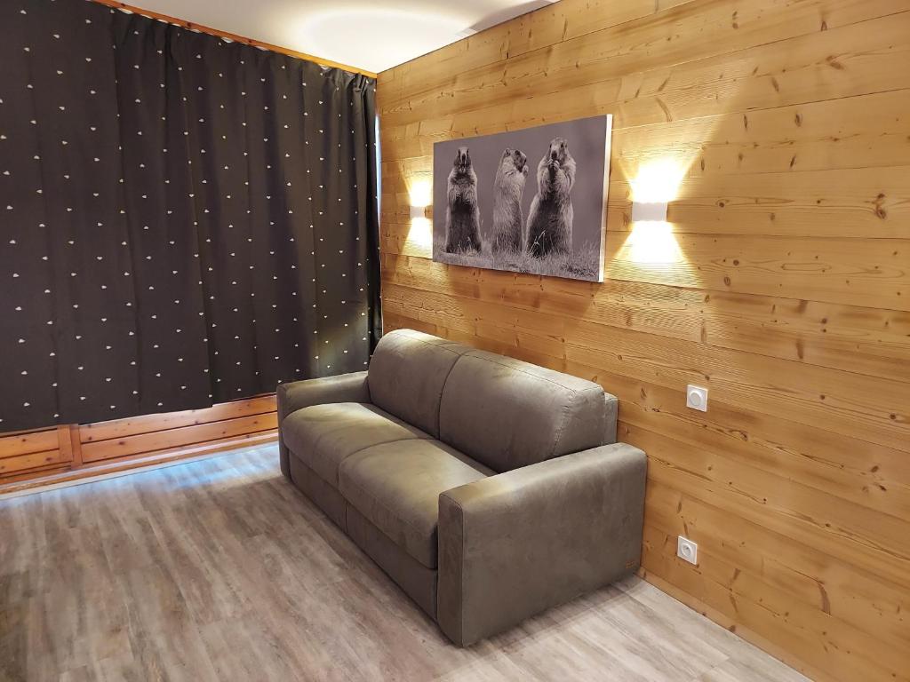 um sofá de couro num quarto com paredes de madeira em ARC 1800, Résidence les Lauzieres em Arc 1800