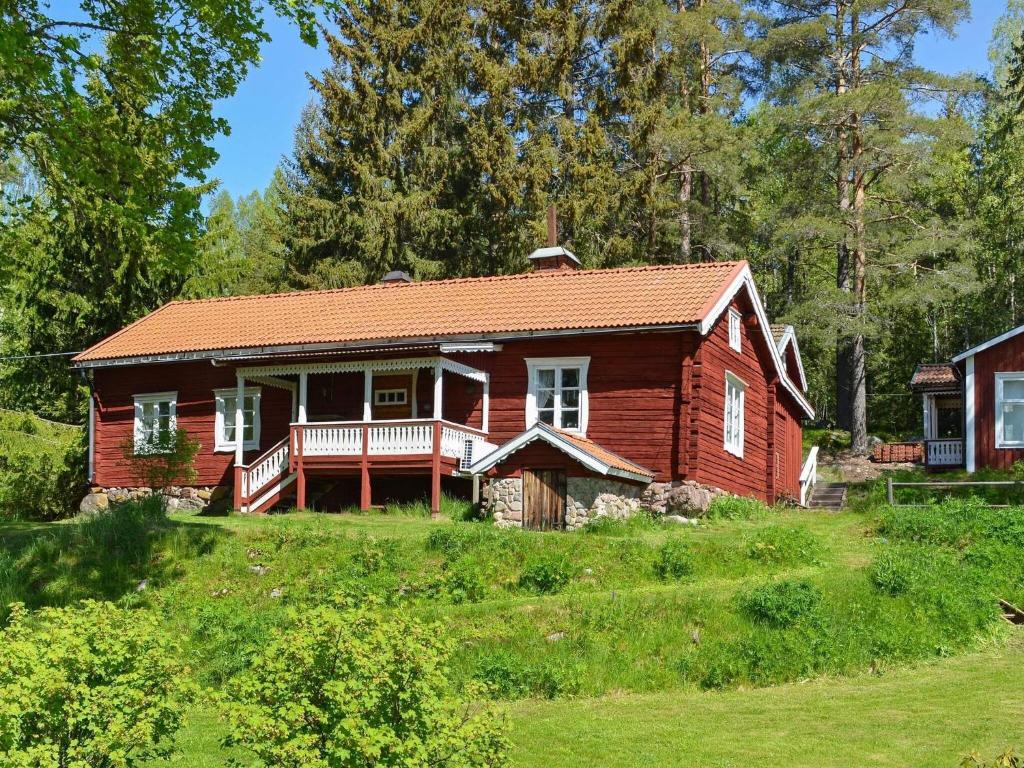 a small red house on a hill with trees at 7 person holiday home in J RBO in Åshammar