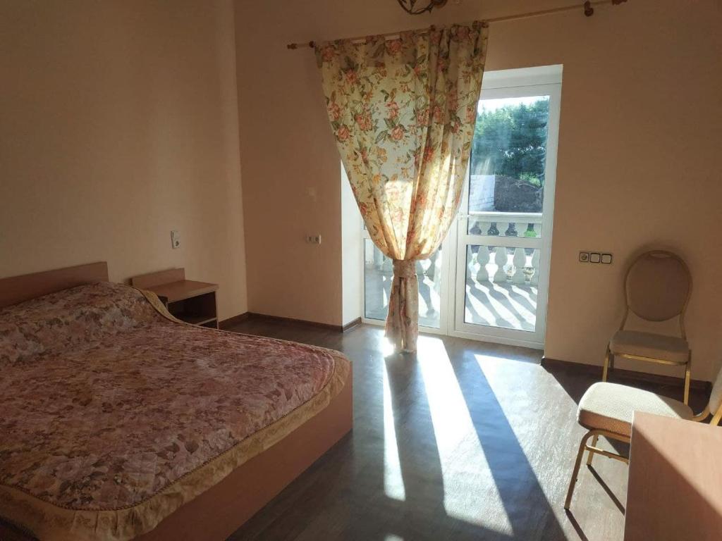 ein Schlafzimmer mit einem Bett und einem großen Fenster in der Unterkunft Вилла Александра in Bolʼshaya Balka