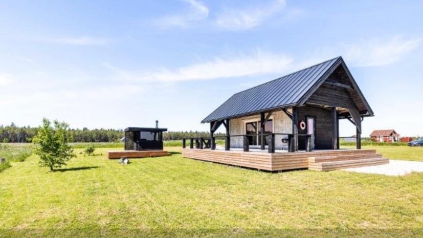 a large building with a black roof on a grass field at Spithami Seaside Wooden Chalet in Spithami