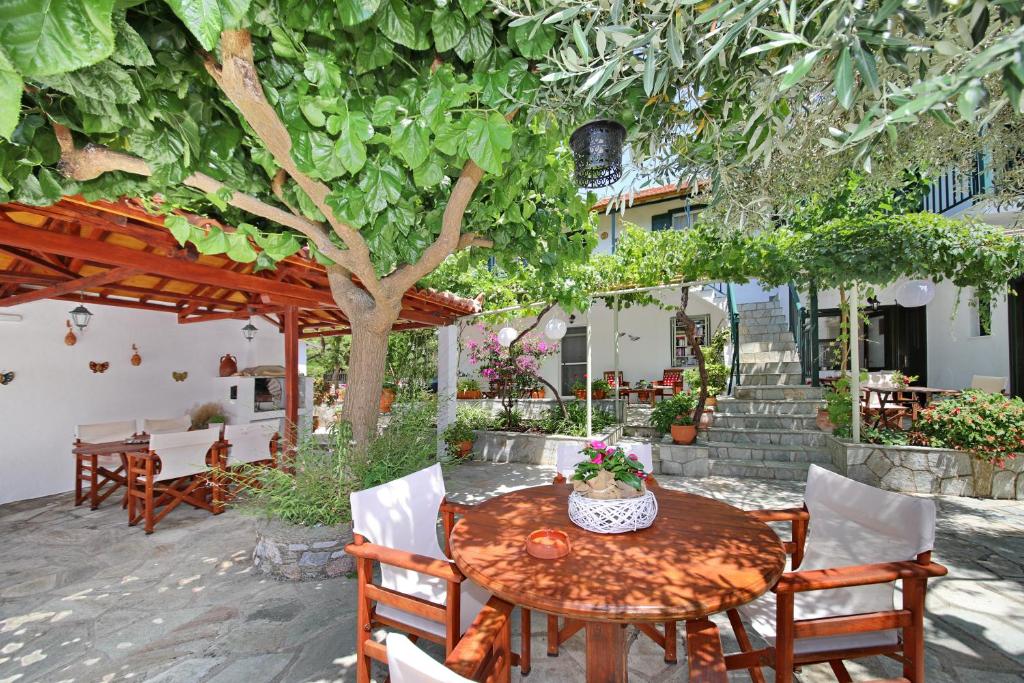 a wooden table and chairs under a tree at Katerina in Panormos Skopelos
