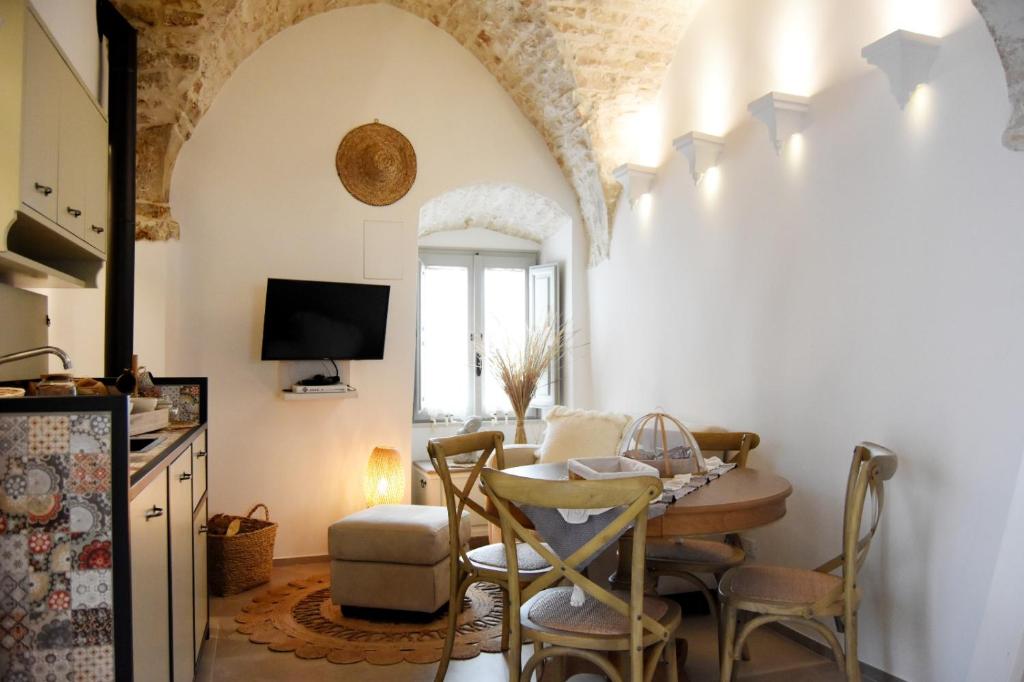 cocina y comedor con mesa y sillas en Alcova Cellini Bell'Italia, en Cisternino