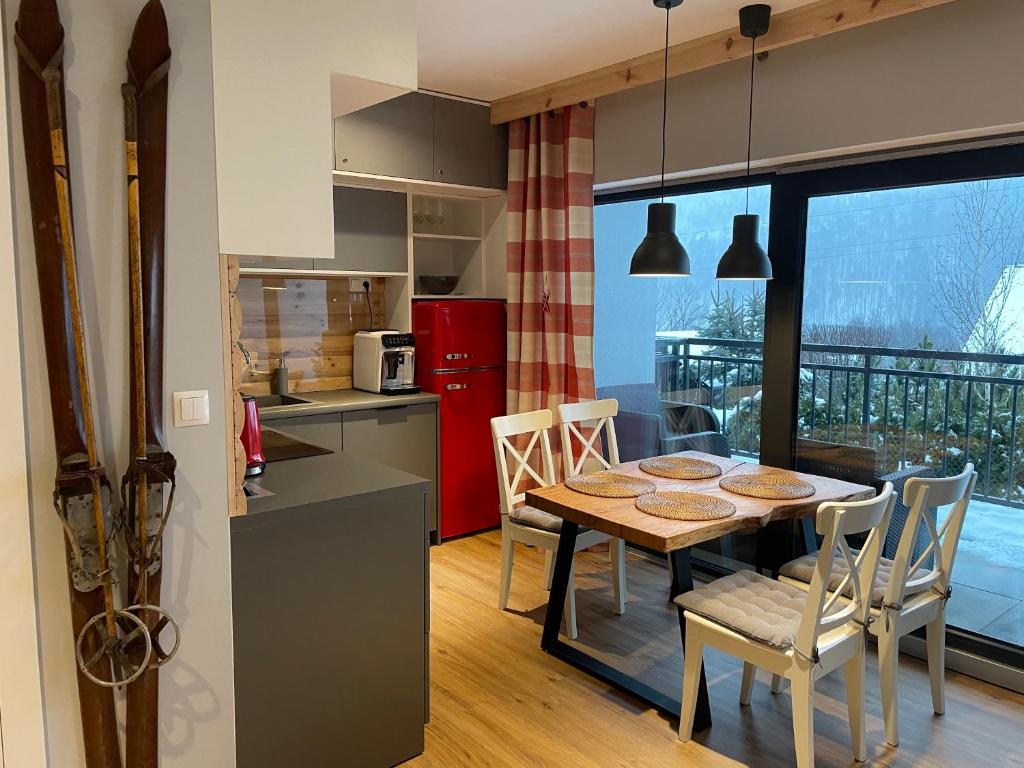 kuchnia i jadalnia ze stołem i krzesłami w obiekcie Apartament Na Górce, sauna & jacuzzi w Szczyrku