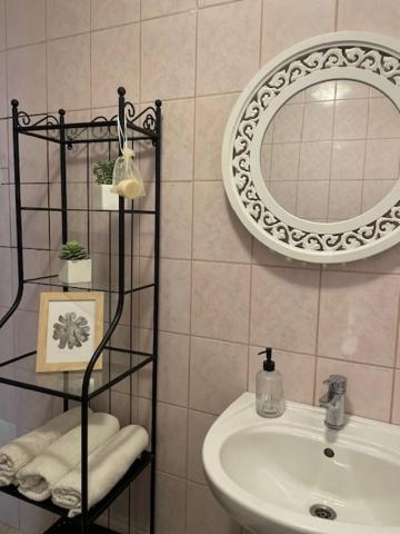 W łazience znajduje się umywalka i lustro. w obiekcie BONI Apartman w Miskolc-Tapolca
