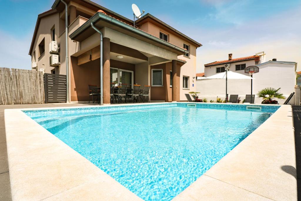 a swimming pool in front of a house at AS Apartmani "Chocolate" in Peroj