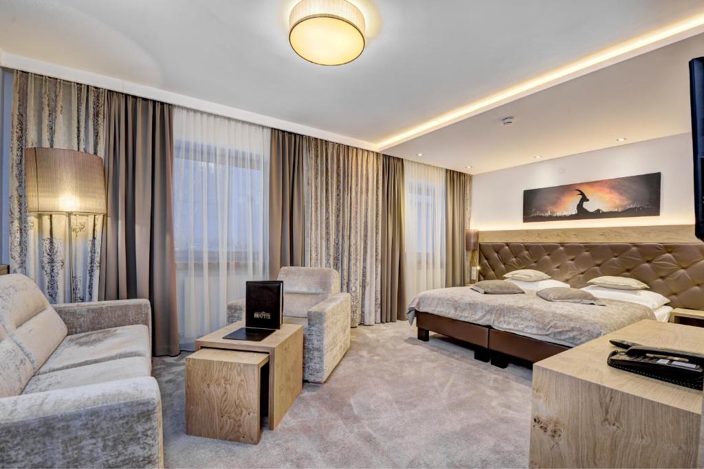 a hotel room with two beds and a couch at Hotel Brigitte in Ischgl